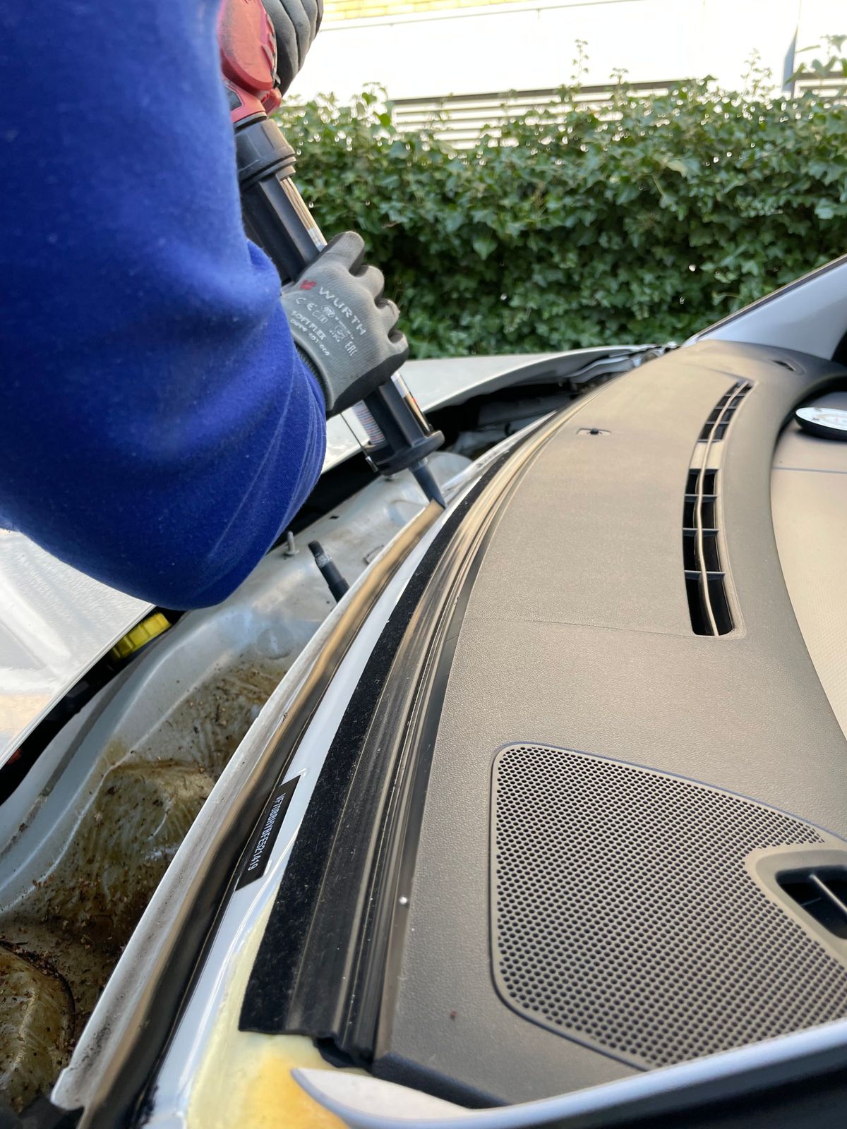 Adhesive being applied along the frame before a windshield is fitted